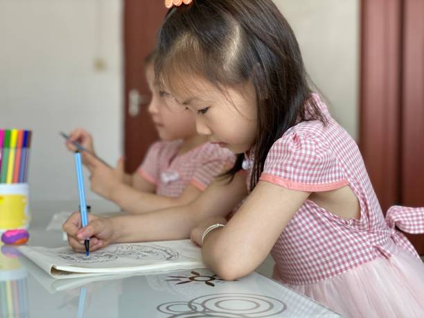 istock Two little Asian girls are drawing 1411937444