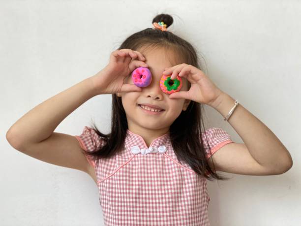istock Asian child holding mini donuts 1411939221