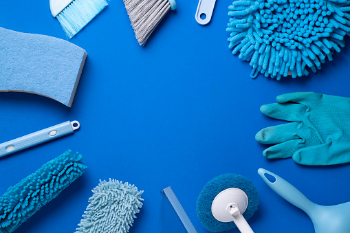House cleaning plastic product on wood table with blue background, home service or housekeeping concept
