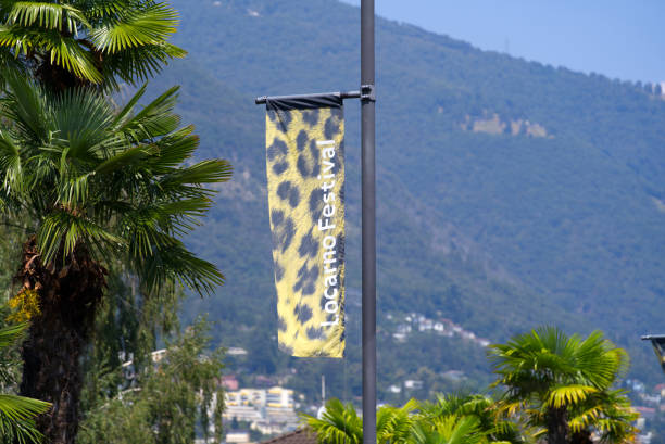 leopard fur flag waving at swiss city. - locarno imagens e fotografias de stock