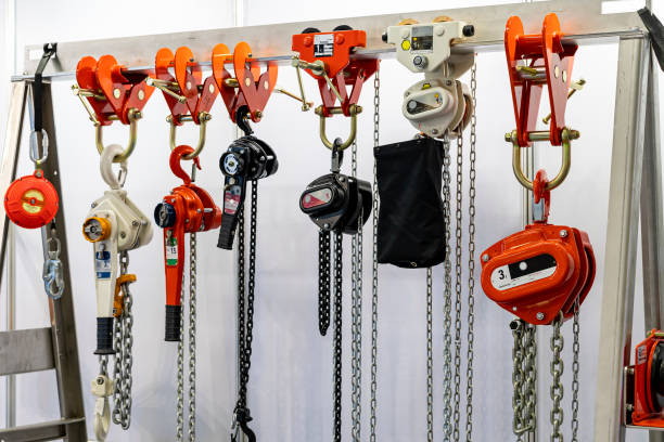 Close up various kind of industrial manual chain hoist such as hand pull and lever type for lifting object and reduce work load storage on hanger line stock photo