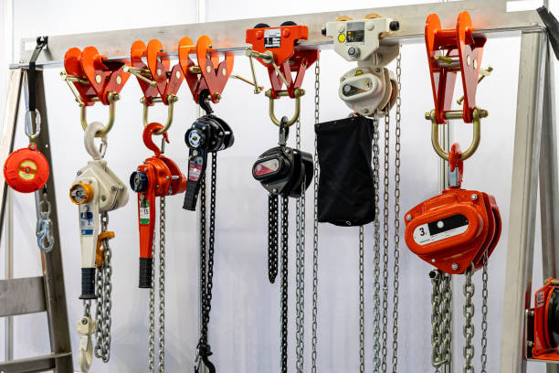 close up various kind of industrial manual chain hoist such as hand pull and lever type for lifting object and reduce work load storage on hanger line - pulley hook crane construction imagens e fotografias de stock