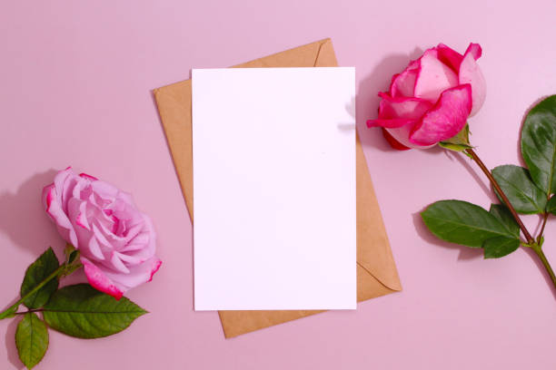 istock Creative concept, greeting card template. Styled feminine flat lay on pale peach background, top view. Minimal woman's desktop with blank page mock up, envelope, rose flowers. 1411945576