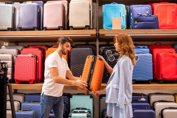istock Young couple seen while choosing a perfect suitcase in a store during a weekend shopping experience 1411946838