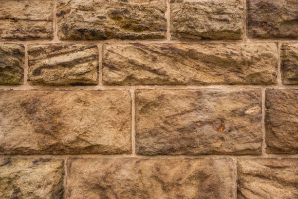 Background texture of a sandstone wall Geometric stone wall background texture, consisting of very large, roughly carved sandstone blocks old stone wall stock pictures, royalty-free photos & images