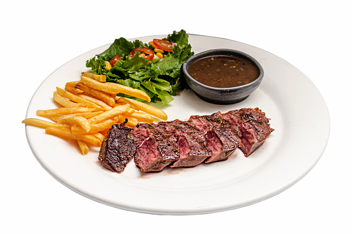 A White Plate of Medium Rare Beefsteak served with French Fried and Salad