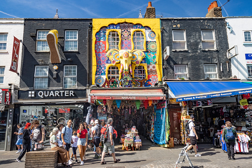 Tourists walking outside several shops including the Namaste Store on Camden High Street in Borough of Camden, London. It sells fabrics and ethnic jewelry.