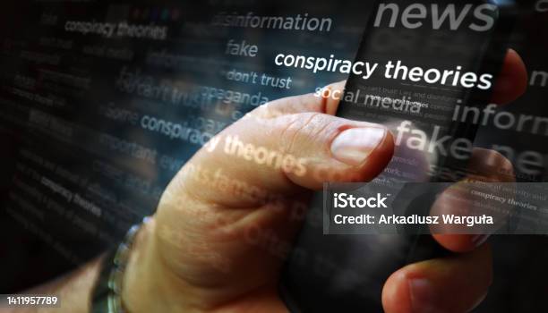 News Titles On Screen In Hand With Conspiracy Theories3d Illustration Stock Photo - Download Image Now