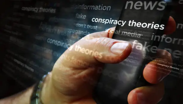 Photo of News titles on screen in hand with Conspiracy theories3d illustration