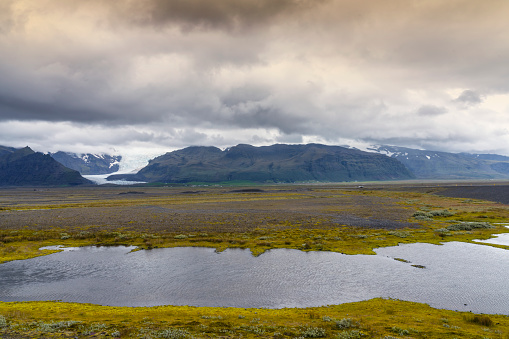 Panorama of Icelandic interior or Highlands. In background is Langjökull, the second largest ice cap in Iceland. In front view river, melted glacier.