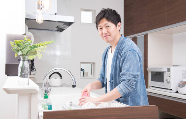 istock Japanese young man doing the dishes 1411961180