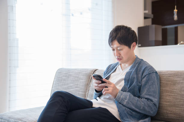 istock man using a smartphone in his living room 1411961195