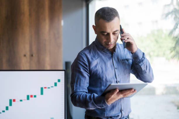 istock Businessman making a phone call about his trading operations 1411962823