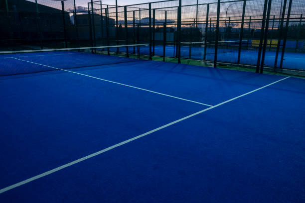 vista de uma quadra de t�ênis de remo azul ao anoitecer, conceito de esportes de raquete - tennis court sport net - fotografias e filmes do acervo