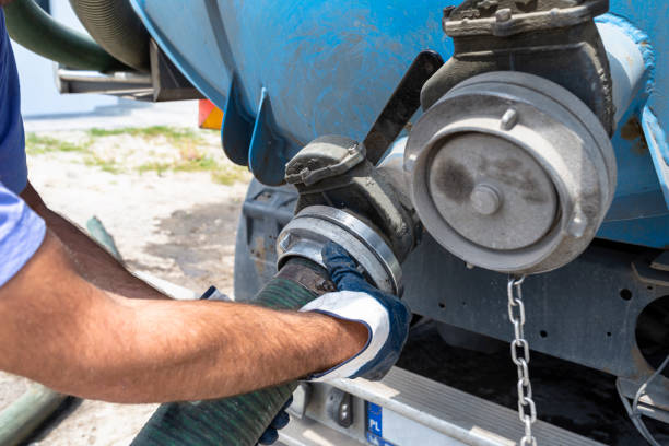 The man connects a 4 inch PVC suction hose to the flange fitting on the trucks tank. The man connects a 4 inch PVC suction hose to the flange fitting on the trucks tank. fuel tanker stock pictures, royalty-free photos & images