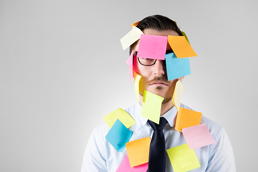 Office worker with post-its all over his face