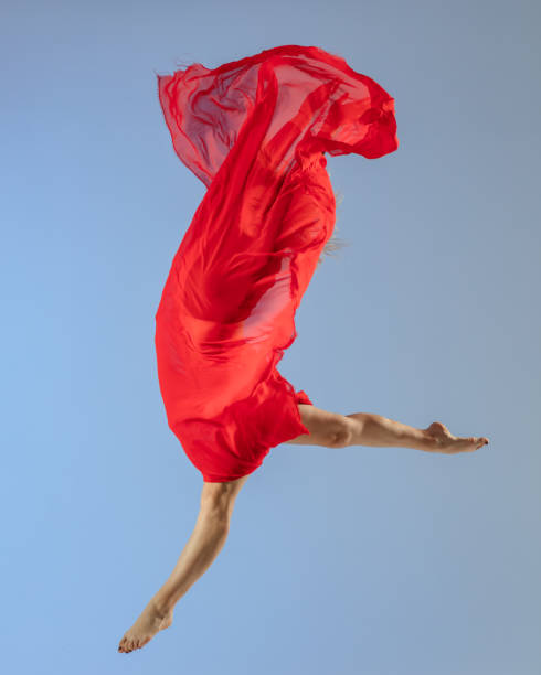 istock Dancer jump on blue background with red fabric 1411969633