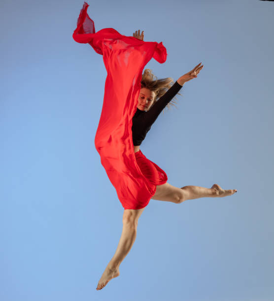 istock Dancer jump on blue background with red fabric 1411969637