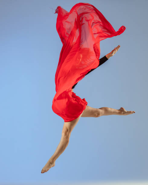 istock Dancer jump on blue background with red fabric 1411969657