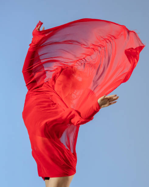 istock Dancer jump on blue background with red fabric 1411969659