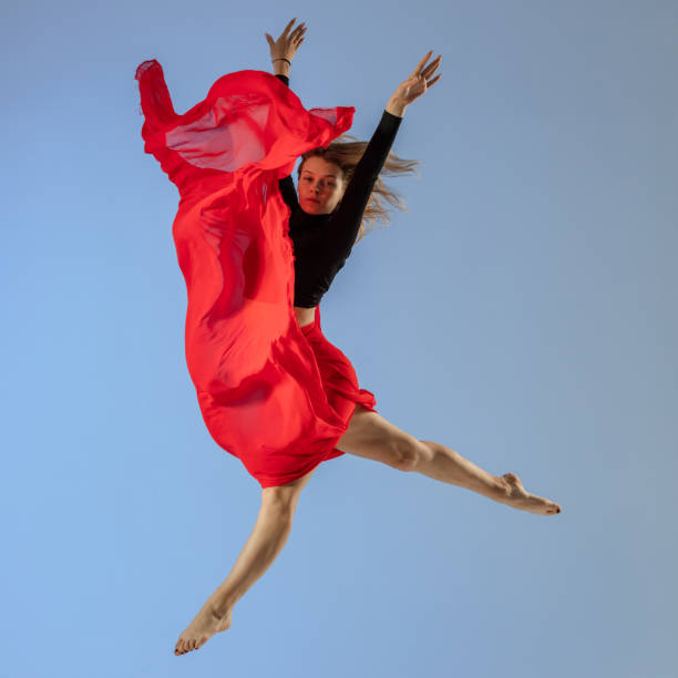 istock Dancer jump on blue background with red fabric 1411969666
