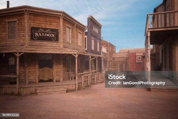 Empty Dirt Street In An Old Western Town With Various Wooden Buildings 3d Illustration Stock Photo - Download Image Now