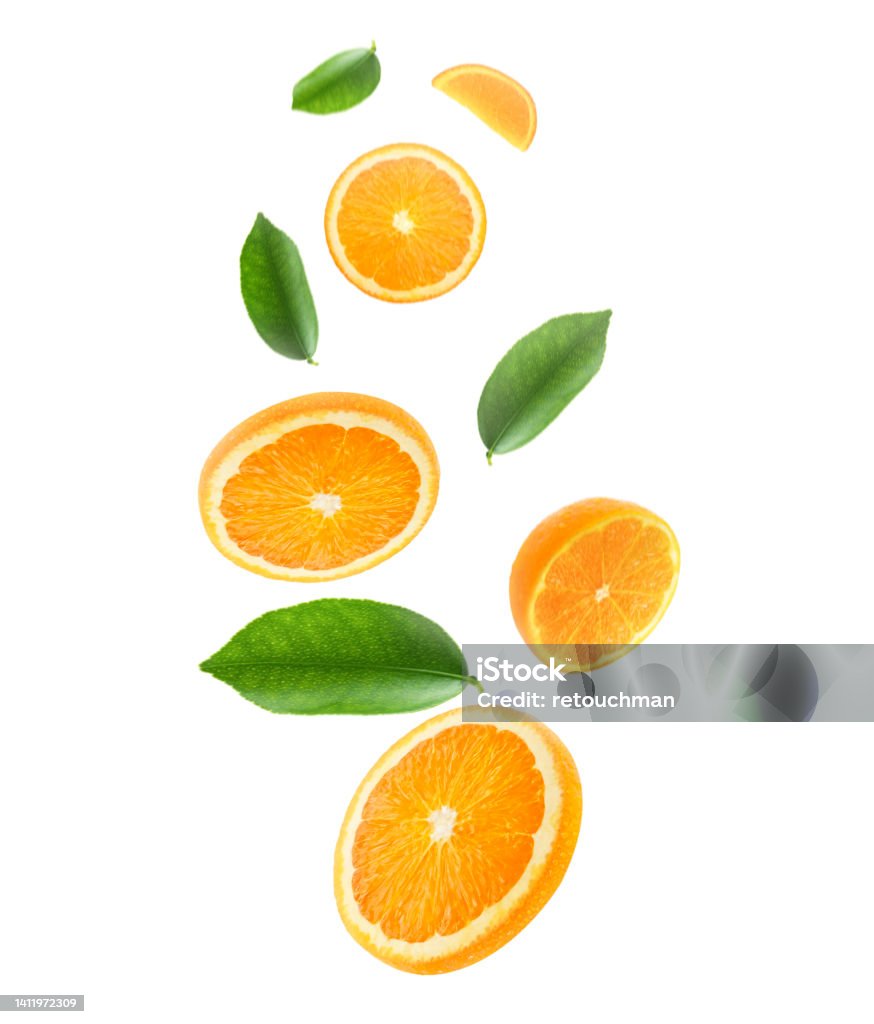 Falling juicy oranges with green leaves isolated on transparent background. Flying defocusing slices of oranges. Applicable for fruit juice advertising Fruit Stock Photo