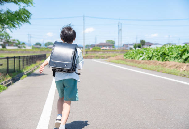 elementary school boy running to school - child rear view running nature imagens e fotografias de stock