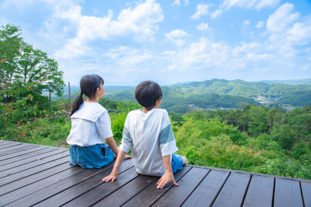 山頂からの眺めを眺める日本の小学生 - 座る ストックフォトと画像