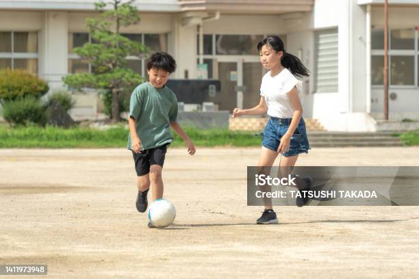 学校でサッカーをしているアジアの小学生