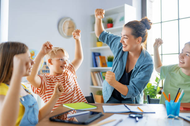 istock Happy kids and teacher at school 1411977440