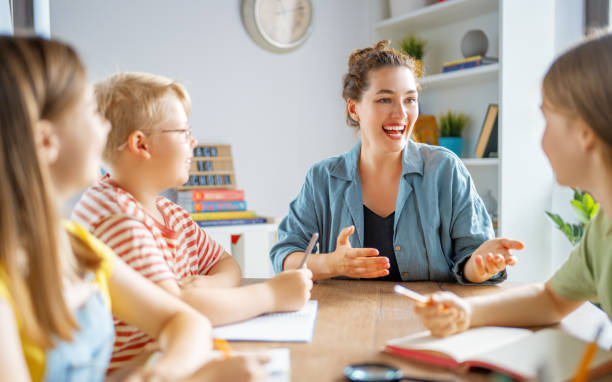 istock Happy kids and teacher at school 1411977606