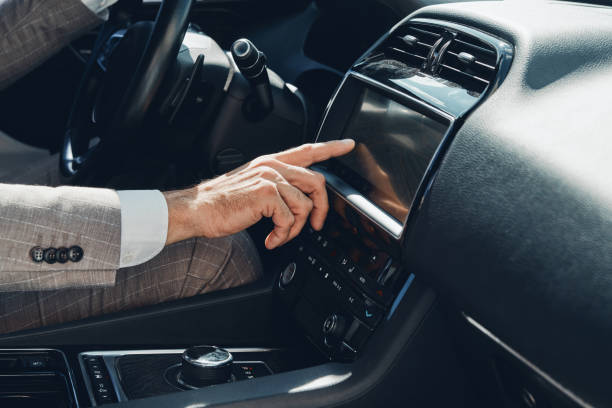 istock Close-up of man using control panel while sitting on the front seat of a car 1411978673