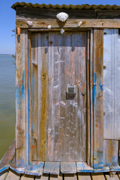 Door made of worn wood roten in a fisherman cabin over the river or sea water