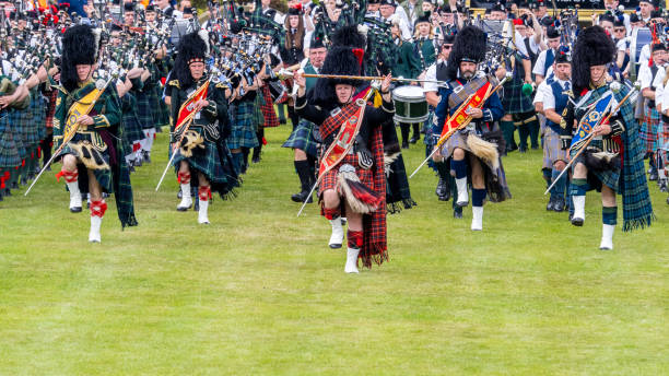 Drum Majors leading the Massed Pipe Bands at Dufftown Highland Games, Scotland Dufftown, Scotland, UK - July 30, 2022: Drum Majors leading the Massed Pipe Bands at Dufftown Highland Games, Scotland. Massed pipe bands, where a number of smaller pipe bands march together playing traditional tunes on bagpipes and drums, are a feature at Highland Games held in Scotland during the summer, which are a part of Scottish culture and a popular day out for both tourists and local people alike. sporran stock pictures, royalty-free photos & images