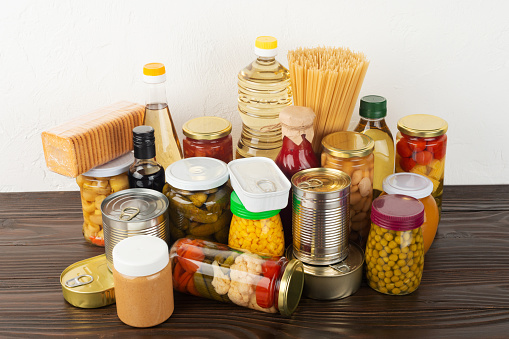 Emergency survival food set on dark wooden kitchen table