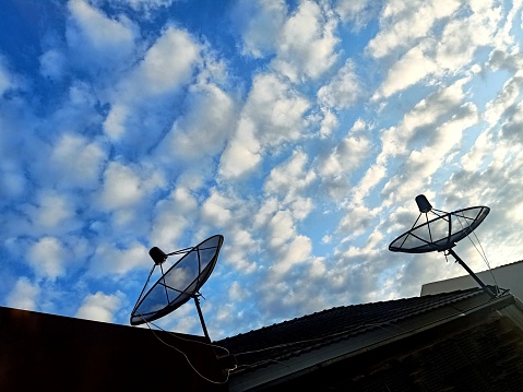 Satellite dishes with cloudy blue sky on background, take it photo in my home chonburi province, Thailand