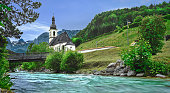 Panorama Pfarrkirche St. Sebastian in Ramsau near Berchtesgaden with the clear green river.
