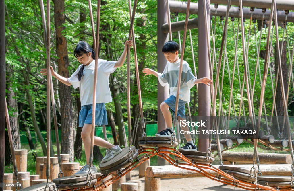 Asian elementary school students playing in nature during summer vacation - Royalty-free Kind Stockfoto