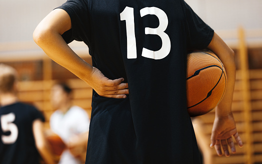 Basketball jersey on hanger against wooden background close up