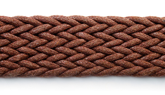 Close up of brown woven textile belt on white background