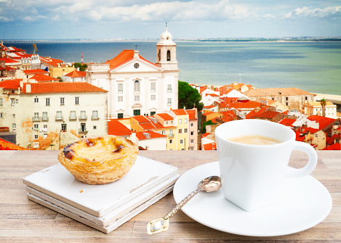 cafe with pasteles de nata and view of Alfama old town at sunny day, Lisbon, Portugal