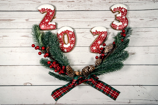 Christmas wreath with the numbers 2023 on a white wooden background. The concept of Christmas and New Year.