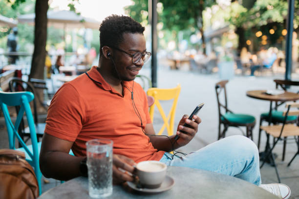 istock Young man sitting in a coffee shop and using a smart phone 1412000653