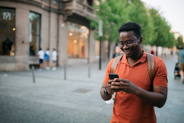 istock Handsome young adult man using a smart phone outdoors 1412000767