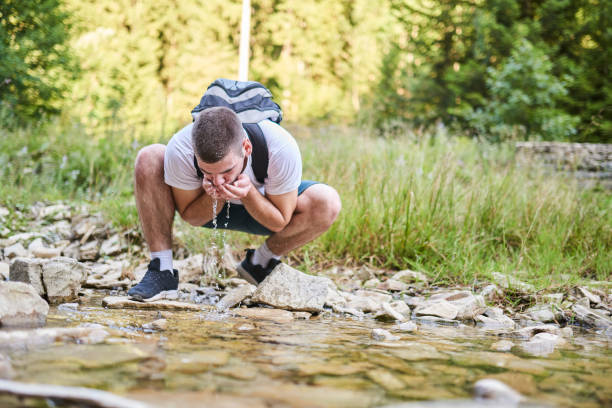 istock Man drinking fresh spring water while trekking. Selective focus. High-quality photo 1412002261