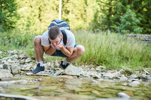 istock Man drinking fresh spring water while trekking. Selective focus. High-quality photo 1412002266