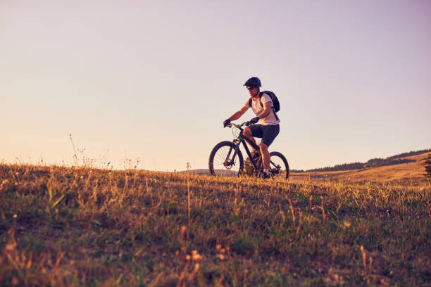 istock A cyclist riding a bike on a mountain at sunset 1412002383