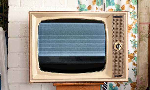 istock Old TV with interference and noise on the screen in a rustic interior. 1412002946
