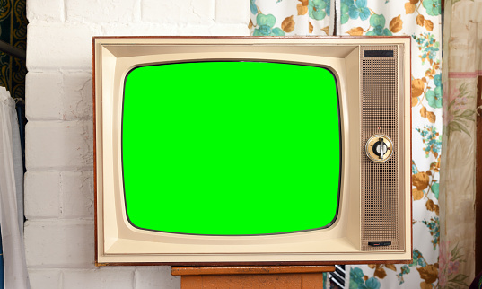 Old green screen TV in a rustic interior.